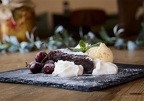 hausgemachter Schoggikuchen mit Glace und Rahm