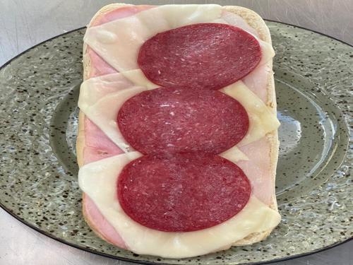 Warme halve stokbrood met ham, kaas en salami